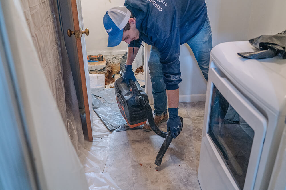 Plumber vacuuming after plumbing installation