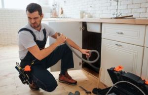 Plumber checking clogged drain