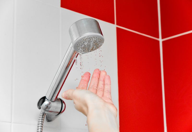 A person under shower checking water coming out slow due to low water pressure