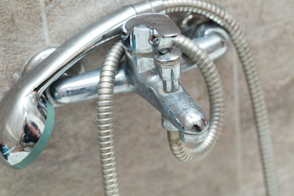 brown, rusty water flowing from a bathtub faucet